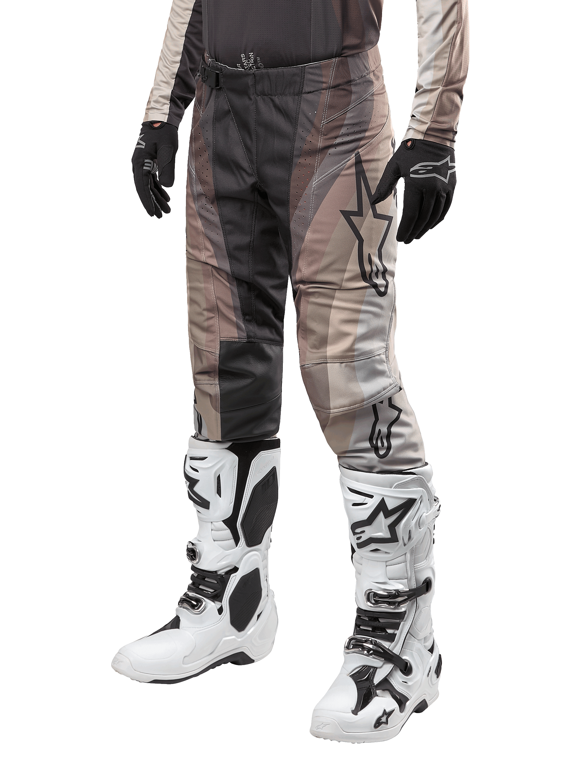 Pantalon Alpinestars Techstar Pneuma 2024, pantalon de motocross, sable foncé et gris poussière de fer, porté avec des bottes blanches et noires et des gants noirs, avec un motif ondulé et un grand logo étoile, équipement durable pour la course tout-terrain