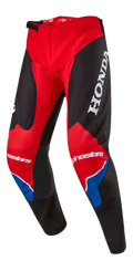 Pantalon Alpinestars Honda Racer Iconic, pantalon de motocross, rouge vif, noir et blanc avec des accents bleus, doté d'un grand logo HONDA blanc sur la cuisse, marquage Alpinestars sur les genoux, construction de jambe pré-courbée ergonomique et fermeture de taille à cliquet réglable.