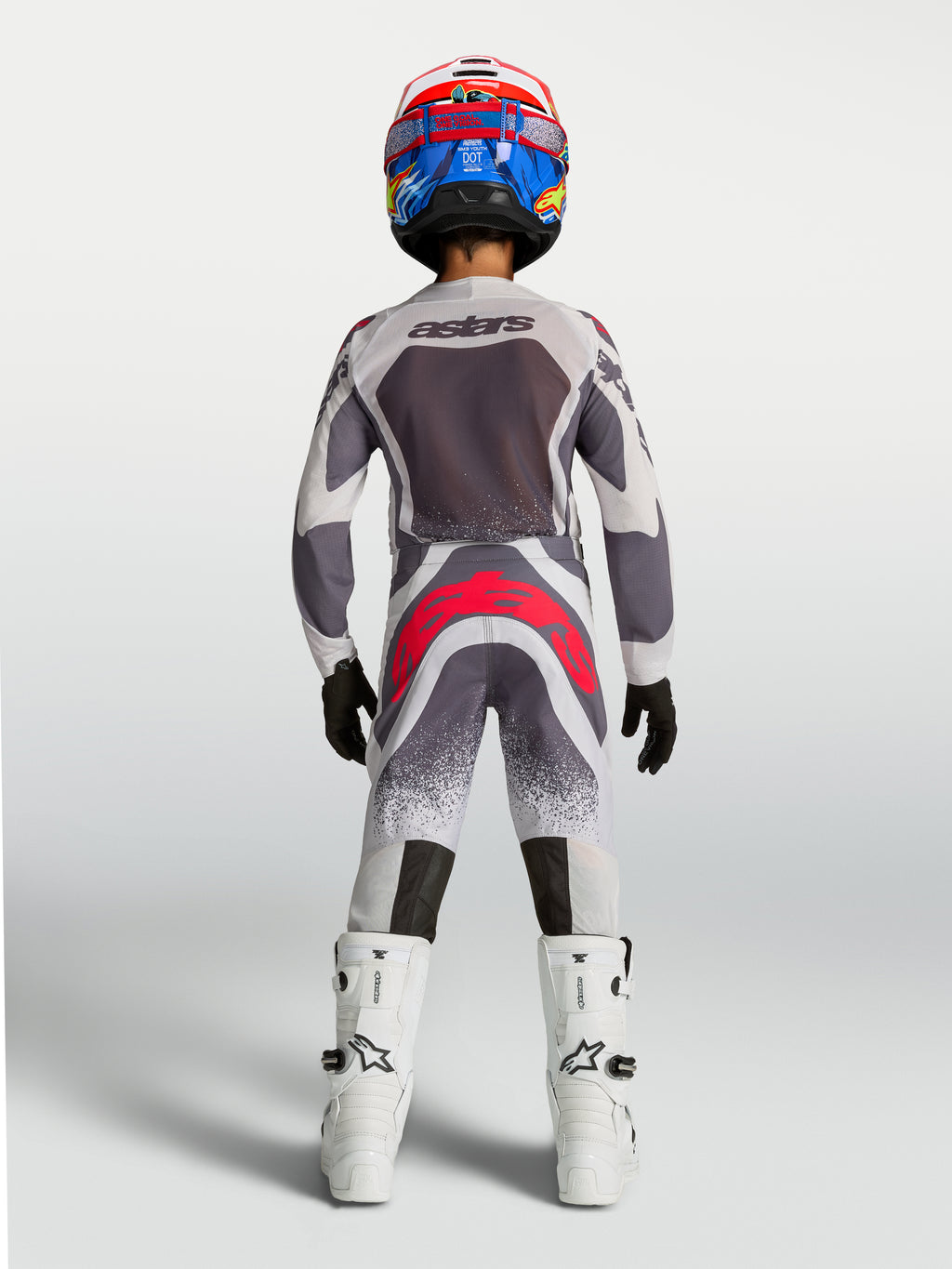 Alpinestars Youth Supertech Swan Pants, gray and red fluo youth motocross racing gear shown from the rear.