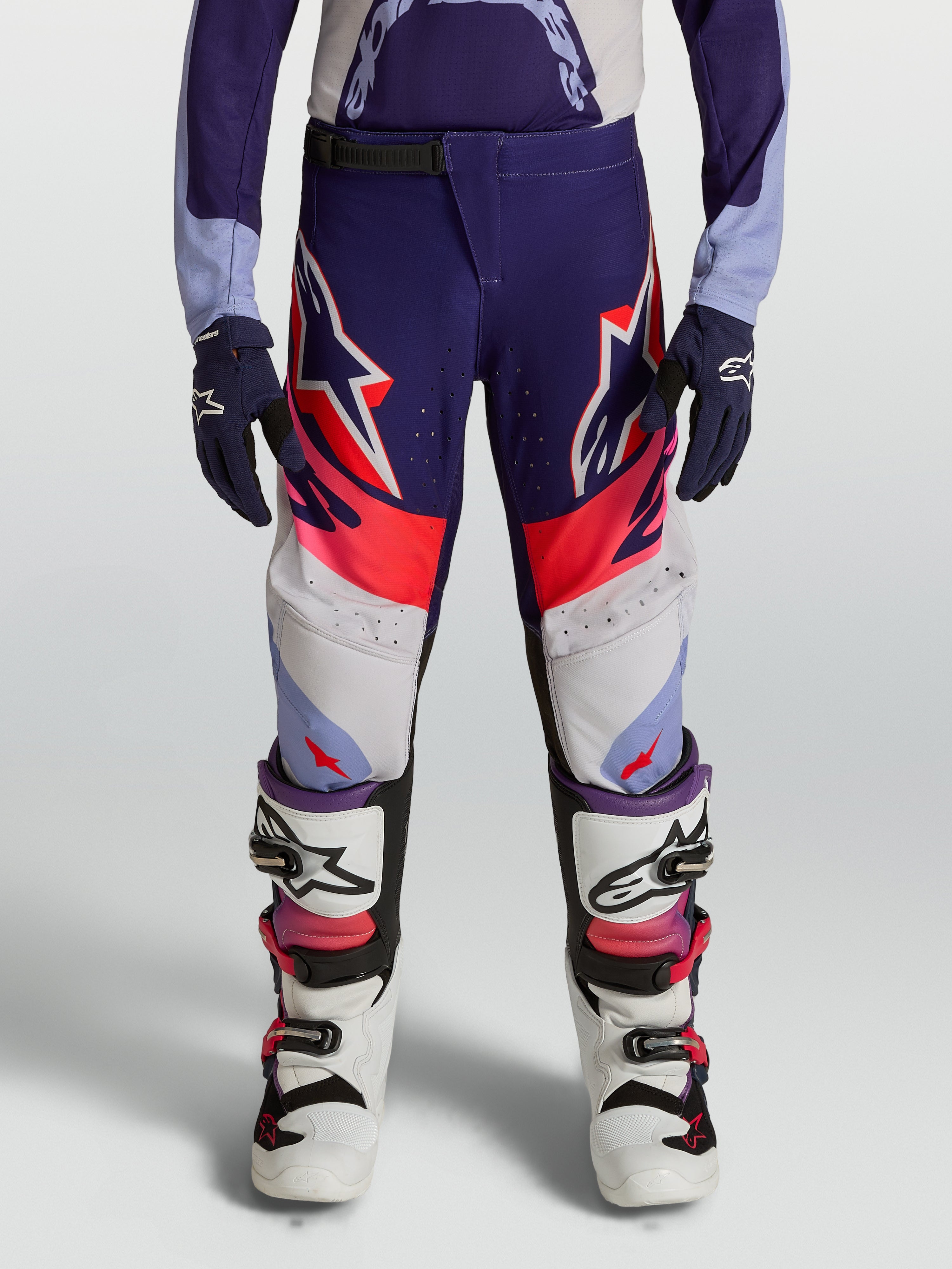 Alpinestars pantalon Supertech Dyna junior de motocross, violet et rose fluo, rip-stop extensible, porté par un pilote.