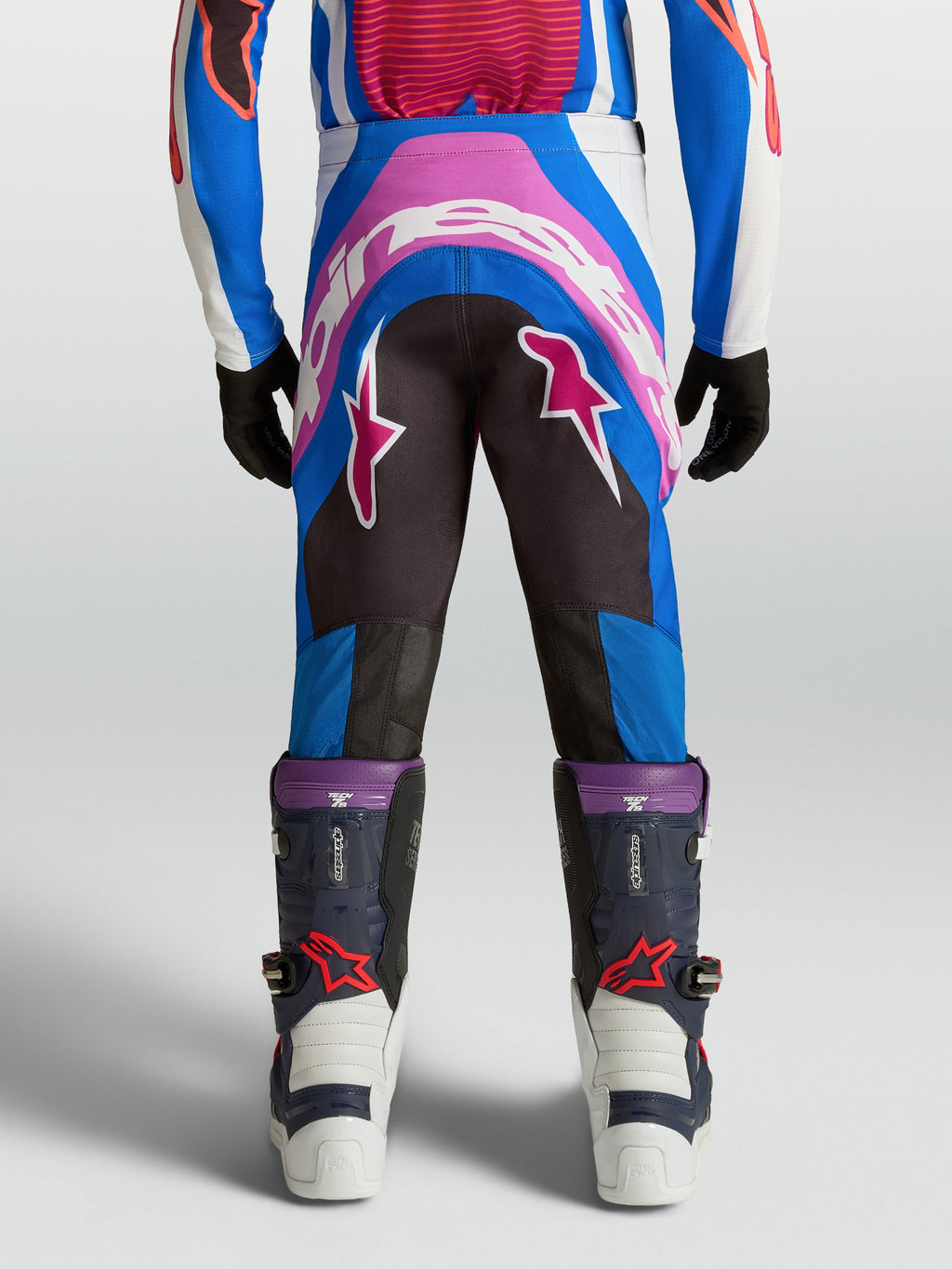 Pantalon Alpinestars Supertech Maven Junior, motocross, bleu et corail, vue de dos avec assise renforcée et coupe athlétique.