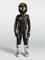 Alpinestars Pantalon Fluid Apex V2 Junior, équipement de motocross noir et argenté pour enfant, avec maillot assorti et bottes blanches, tenue complète de pilotage tout-terrain.
