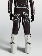 Pantalon Alpinestars Fluid Apex V2 Junior, équipement de motocross noir et argenté, coupe ergonomique et logos Astars.