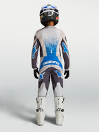 Alpinestars pantalon Fluid Drag Junior, équipement de motocross pour enfant, gris et bleu, vu de dos avec maillot et bottes assortis, conçu pour la performance tout-terrain