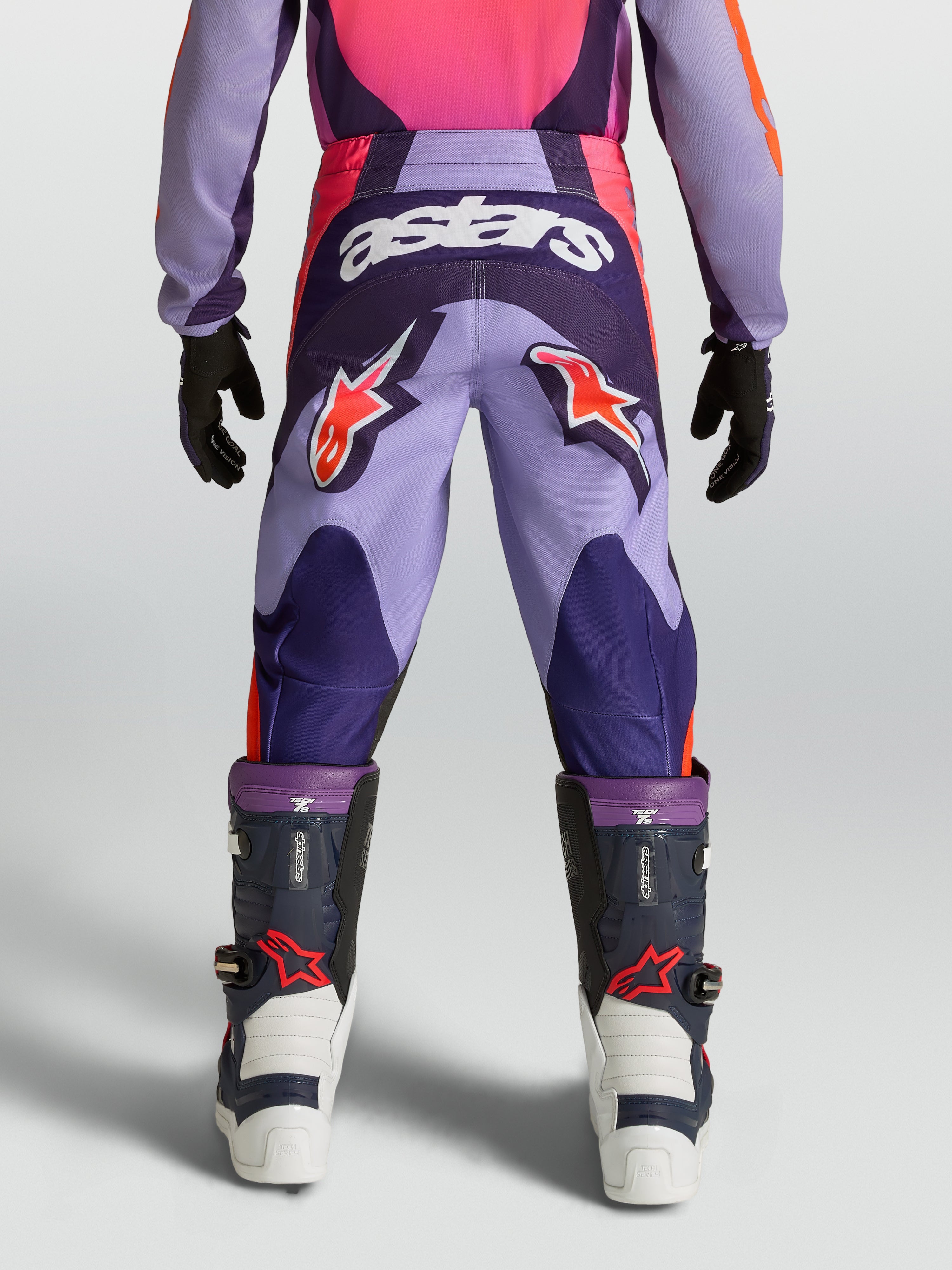 Pantalon Fluid Hunt Junior Alpinestars, pantalon de motocross violet et rose pour enfant avec logos orange, vue de dos.