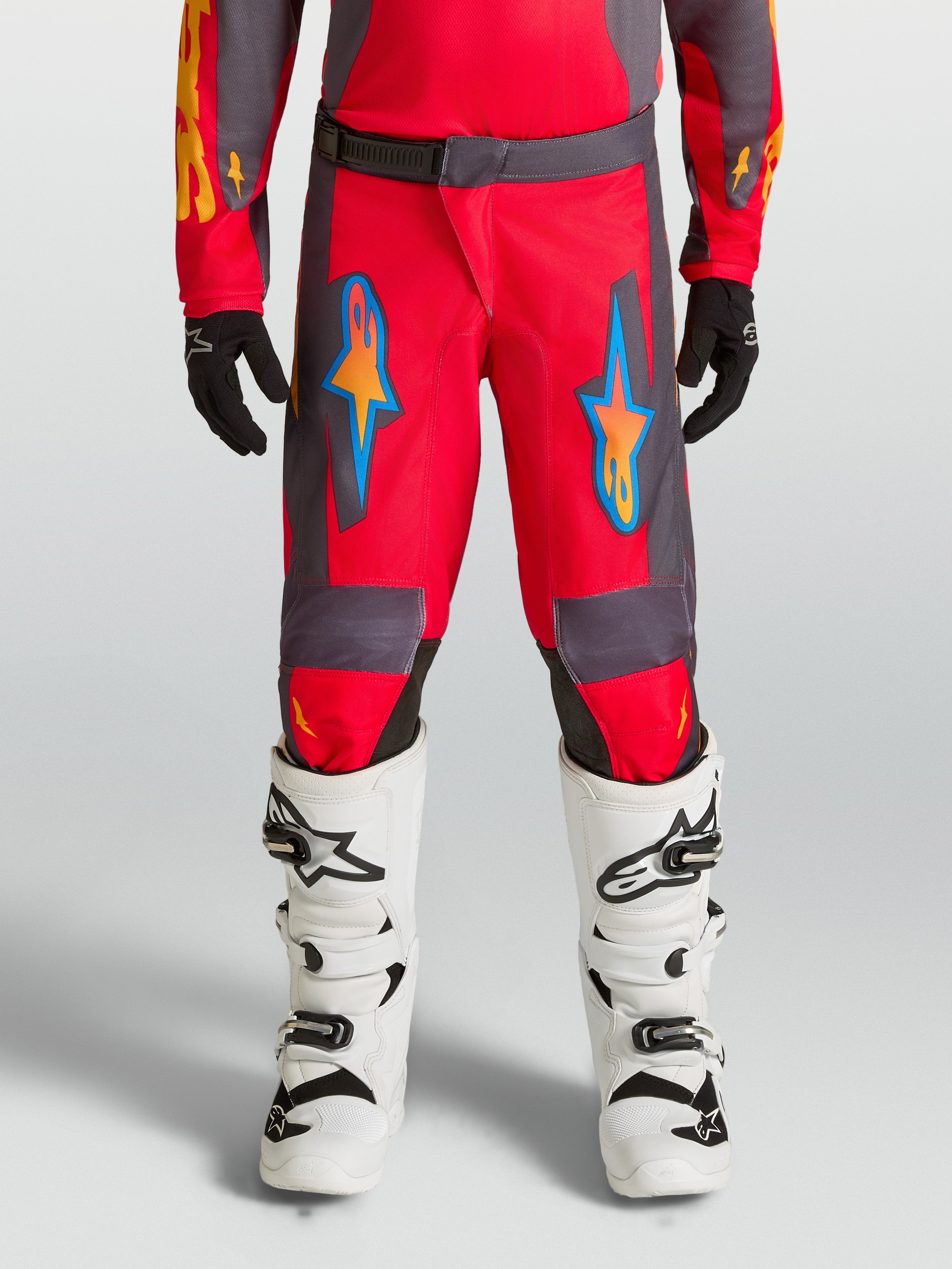 Alpinestars Fluid Hunt Junior, pantalons de motocross rouges et gris pour enfant, design ergonomique en polyfibre.