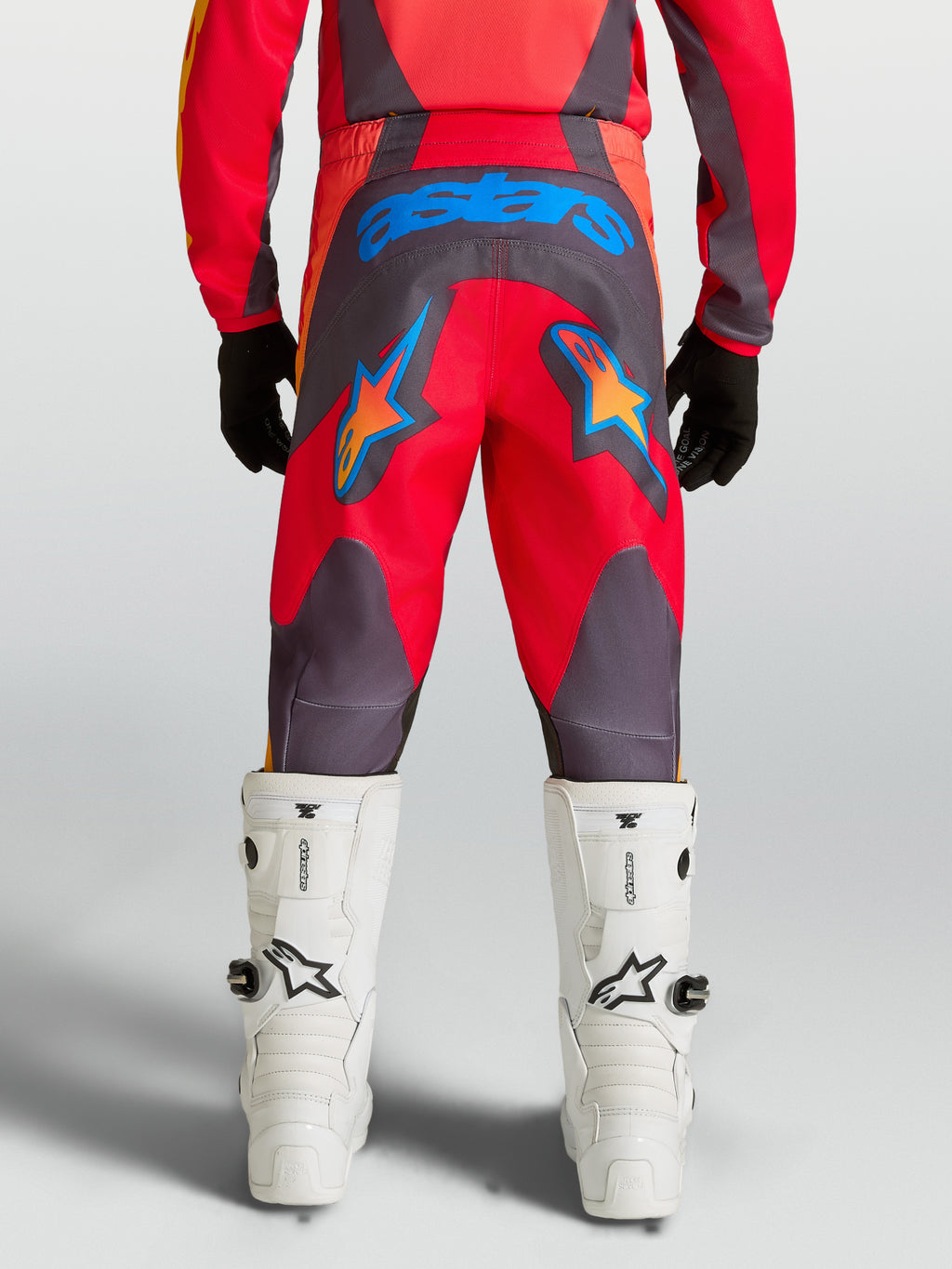 Alpinestars Pantalons Fluid Hunt Junior, équipement de motocross pour enfant, rouges et gris avec étoiles bleues, assise renforcée en polyfibre 600D, vus de dos