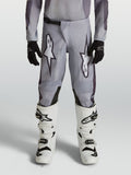 Alpinestars Youth Fluid Amber Pants, durable grey and black motocross pants for young riders in an off-road setting.