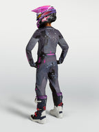 Maillot Fluid Lone Junior Alpinestars, équipement de motocross, gris camouflage et violet, vue de dos sur un jeune pilote.