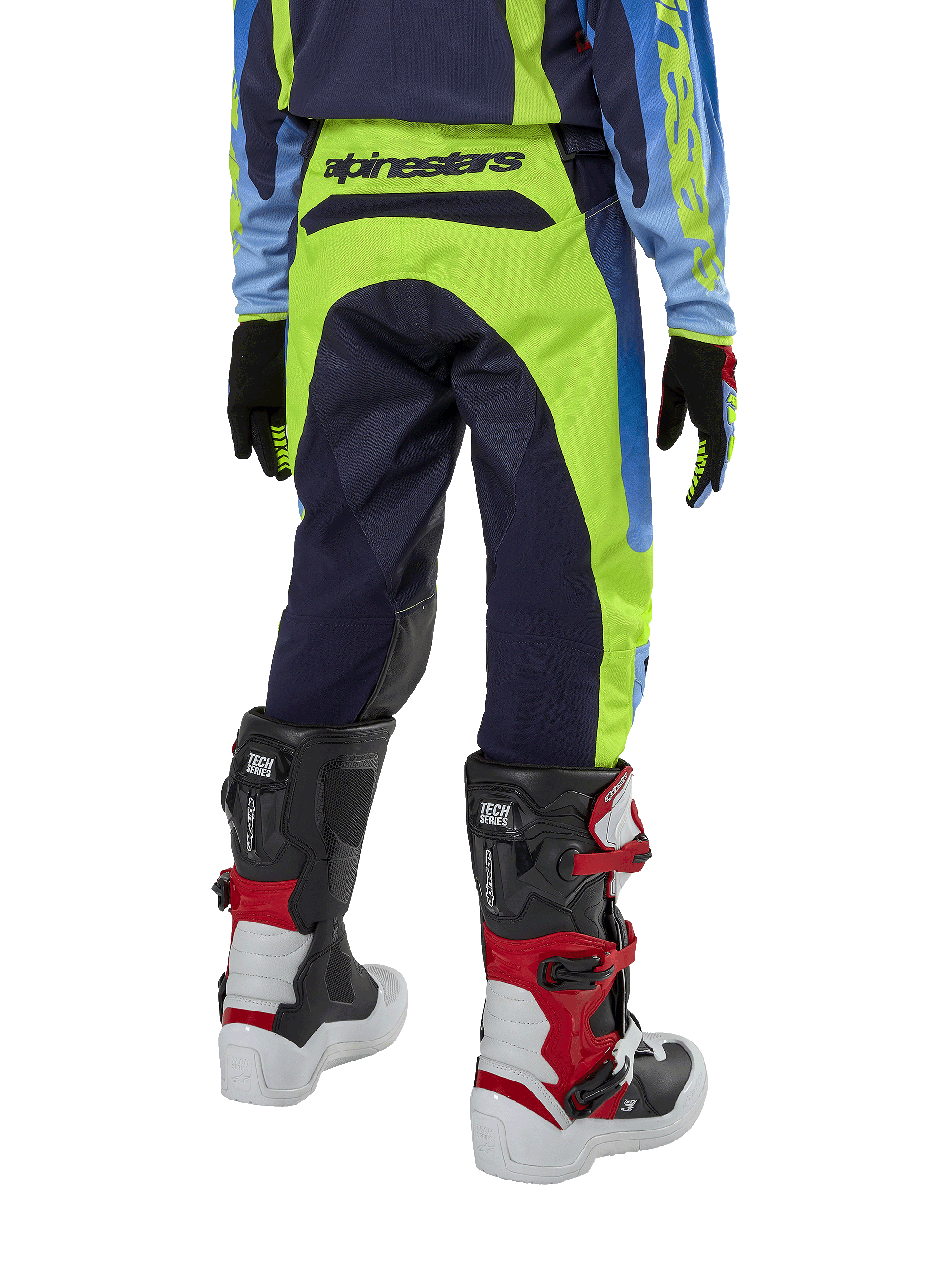 Pantalon Alpinestars Racer Hoen Junior 2024, pantalon de motocross, jaune fluo et bleu marine Night Navy, vue arrière montrant le logo Alpinestars sur la ceinture, porté avec des bottes Tech Series noires et rouges et un maillot assorti, coupe sportive durable pour la conduite tout-terrain des jeunes