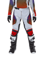 Pantalon Alpinestars Youth 2024 Racer Hoen, pantalon de motocross, gris clair, orange vif et noir, porté avec le maillot assorti et des bottes de motocross noires et blanches, avec des logos Alpinestars rouges sur les cuisses et les genoux, design sportif pour la course tout-terrain