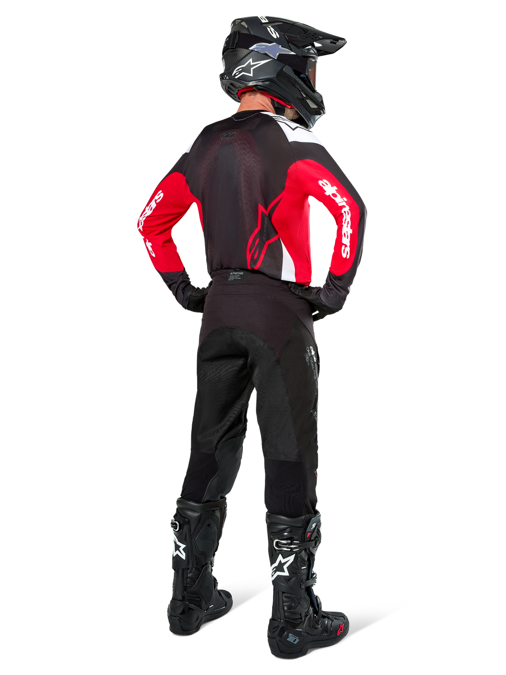 Pilote de motocross vu de dos portant le maillot Alpinestars Pro-Dura noir, rouge vif et blanc, avec pantalon, casque et bottes noirs, montrant le design arrière et les logos sur les manches, équipement de course tout-terrain coordonné