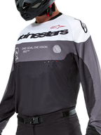 Maillot Alpinestars Pro-Dura, maillot de motocross et d'enduro, Noir Magnétite Blanc, vêtement technique tout-terrain avec perforations découpées au laser et construction en tissu poly respirant.