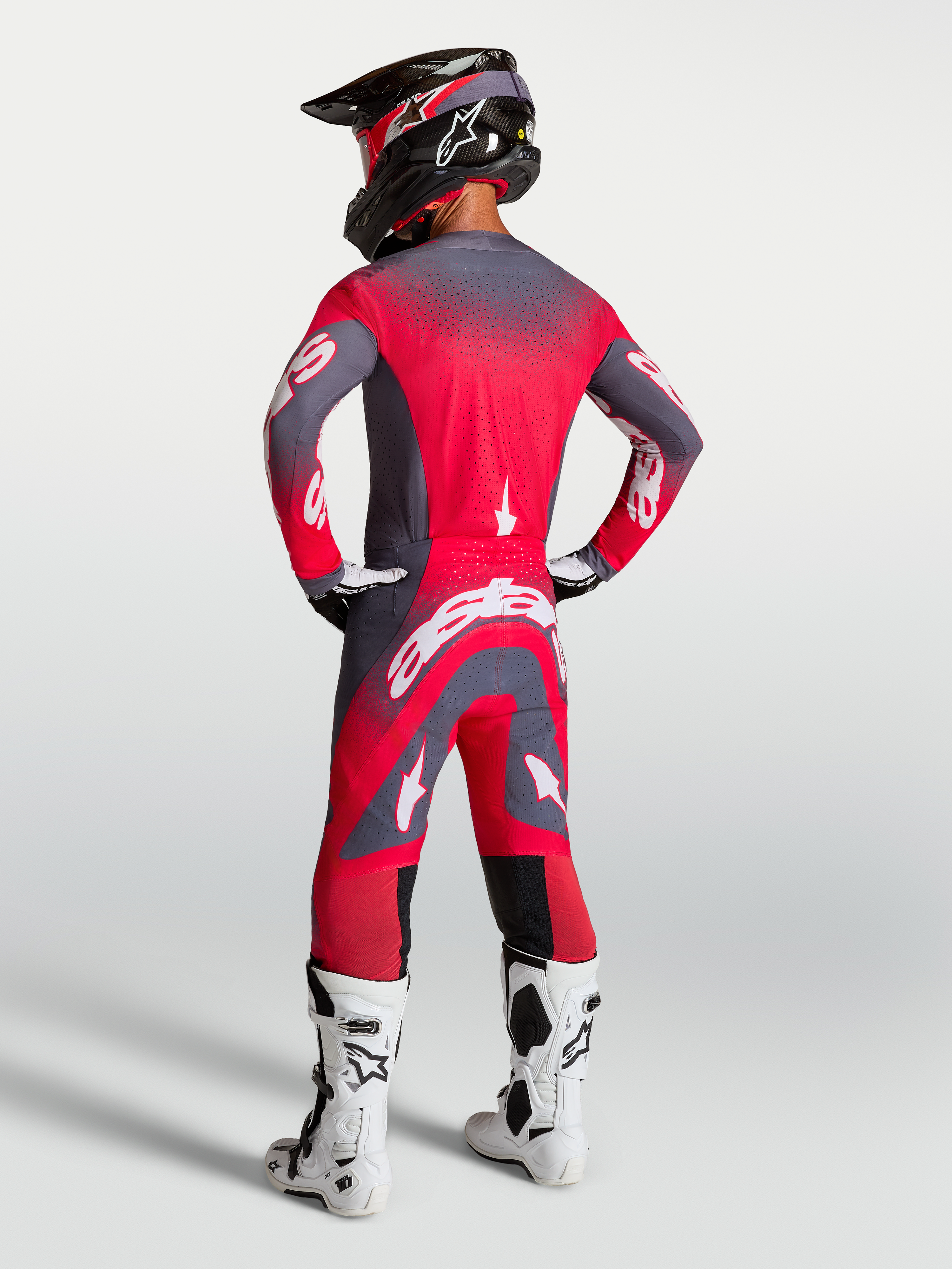 Maillot et ensemble Alpinestars Supertech Hiten AFD, tenue de motocross rouge fluo et gris, vue de dos sur mannequin.