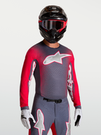 Maillot Alpinestars Supertech Hiten AFD, maillot de motocross pour homme, gris et rouge fluo, mesh respirant et perforations laser pour la ventilation, porté avec casque et gants