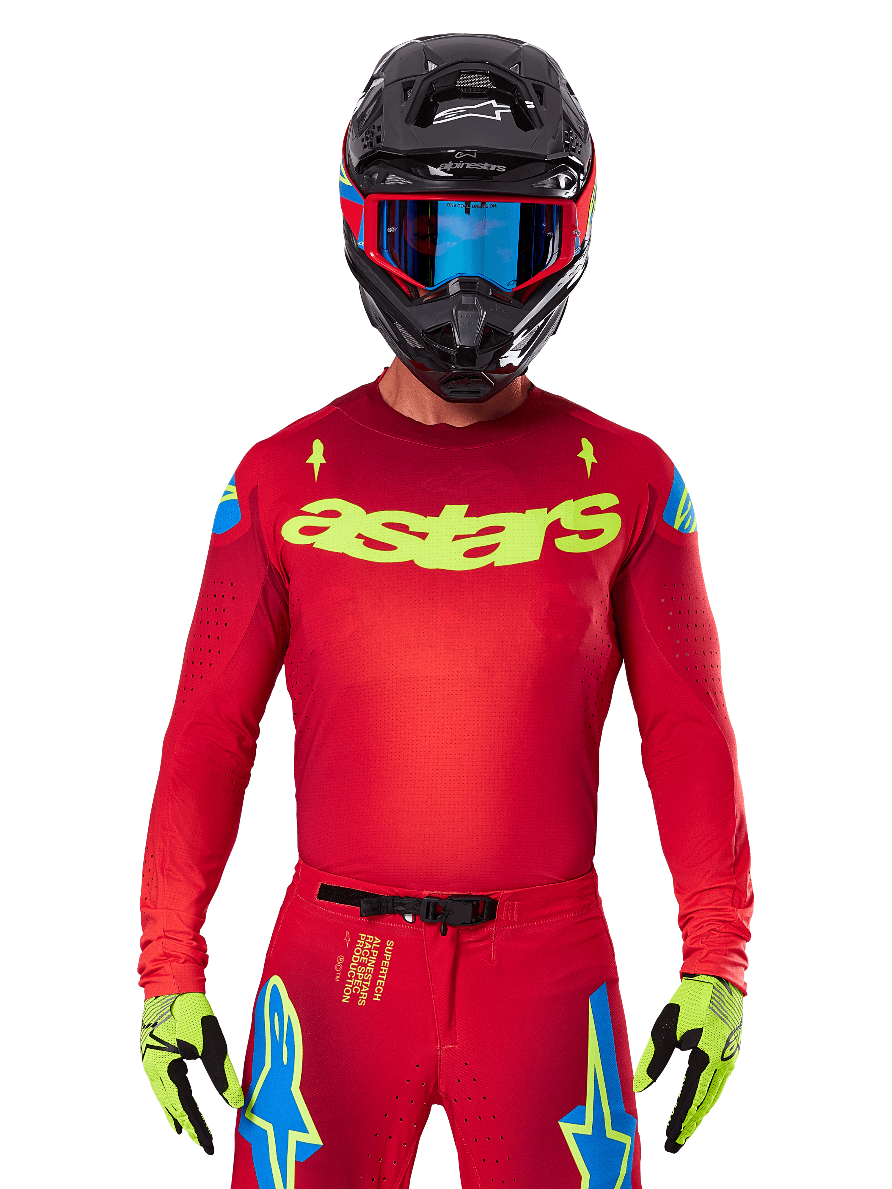 Alpinestars 2025 Supertech Maker Jersey en rouge vif et jaune fluo, avec logo 'astars' jaune sur la poitrine et motifs d'étoiles bleues sur les épaules, porté avec un pantalon assorti, un casque noir, des lunettes bleues et des gants jaunes, équipement de motocross professionnel