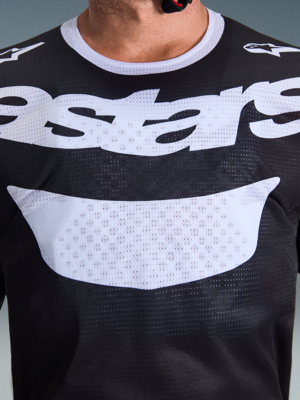 Maillot Alpinestars 2026 Racer Air Riway, maillot de motocross, noir et blanc, gros plan sur la poitrine montrant un grand graphique blanc et une construction en mesh respirant, col blanc et logos sur les épaules