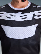 Maillot Alpinestars 2026 Racer Air Riway, maillot de motocross, noir et blanc, gros plan sur la poitrine montrant un grand graphique blanc et une construction en mesh respirant, col blanc et logos sur les épaules