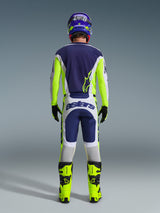 Vue arrière d'un pilote de motocross portant le maillot Alpinestars 2026 Racer Air Riway et le pantalon assorti en gris clair, jaune fluo et bleu, associé à des bottes jaune fluo et un casque coordonné, montrant un équipement de course tout-terrain complet.