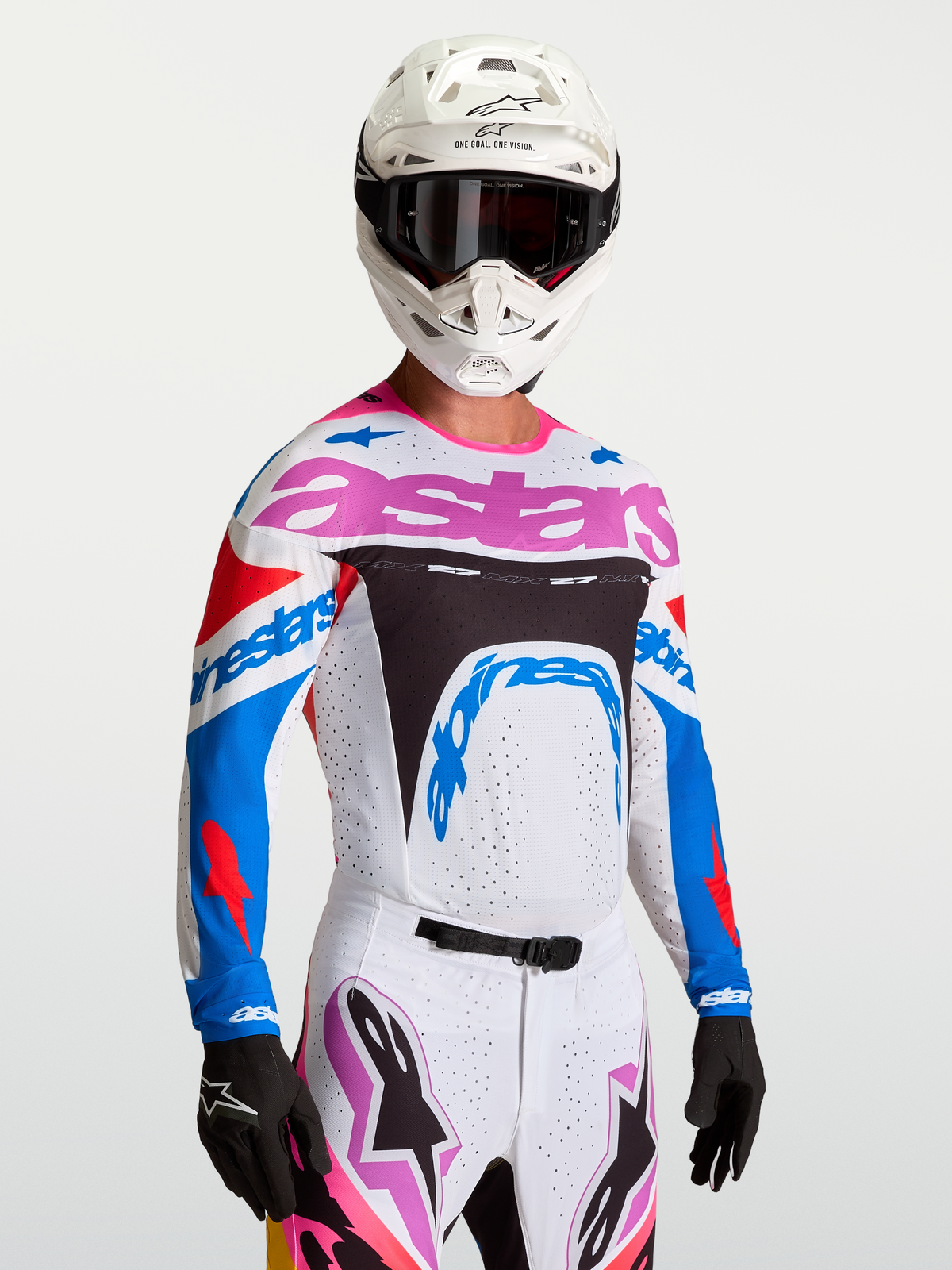 Maillot Alpinestars Supertech Dyna, maillot de motocross blanc et bleu aux accents violets, porté par un pilote avec casque.