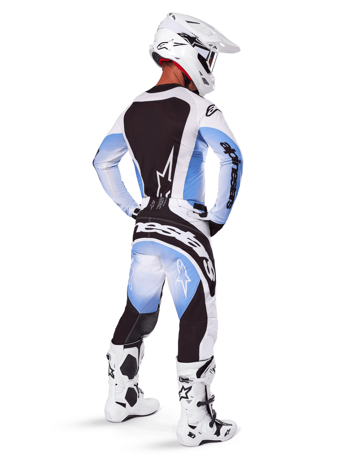 Pilote de motocross portant un équipement de course complet, ensemble Techstar Melt 2025, maillot blanc et bleu clair avec panneau arrière noir, pantalon assorti avec dégradé bleu et accents noirs, casque blanc, bottes blanches et noires, tenue coordonnée pour la course tout-terrain