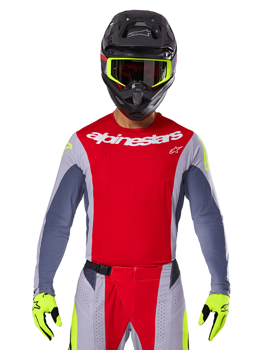 Pilote de motocross portant le maillot Techstar Melt 2025 et le pantalon assorti, rouge vif et gris avec logo Alpinestars blanc, casque noir avec lunettes jaune fluo, gants jaune fluo assortis, équipement de performance ventilé pour la course tout-terrain