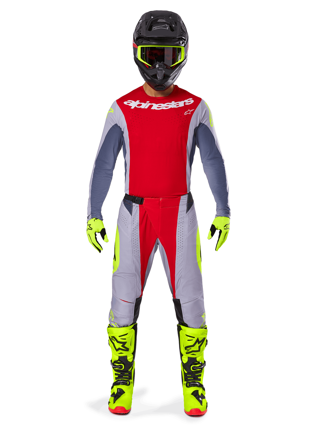 Pilote de motocross portant l'ensemble d'équipement Alpinestars Techstar Melt 2025, maillot rouge avec manches grises et logo blanc, pantalon assorti gris et rouge, lunettes, gants et bottes jaune fluo, tenue de motocross complète pour la performance tout-terrain.
