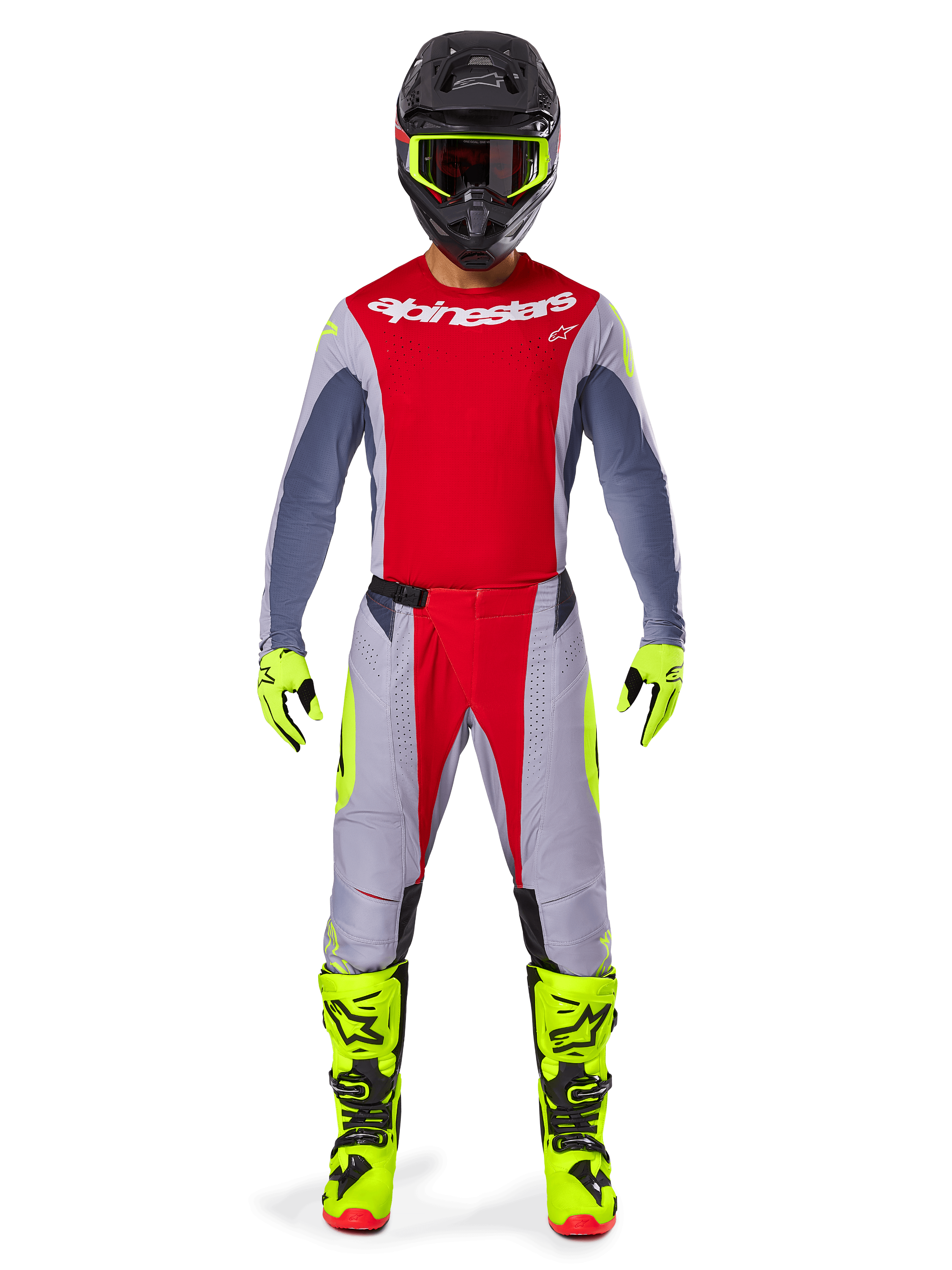 Pilote de motocross portant l'ensemble d'équipement Alpinestars Techstar Melt 2025, maillot rouge avec manches grises et logo blanc, pantalon assorti gris et rouge, lunettes, gants et bottes jaune fluo, tenue de motocross complète pour la performance tout-terrain.