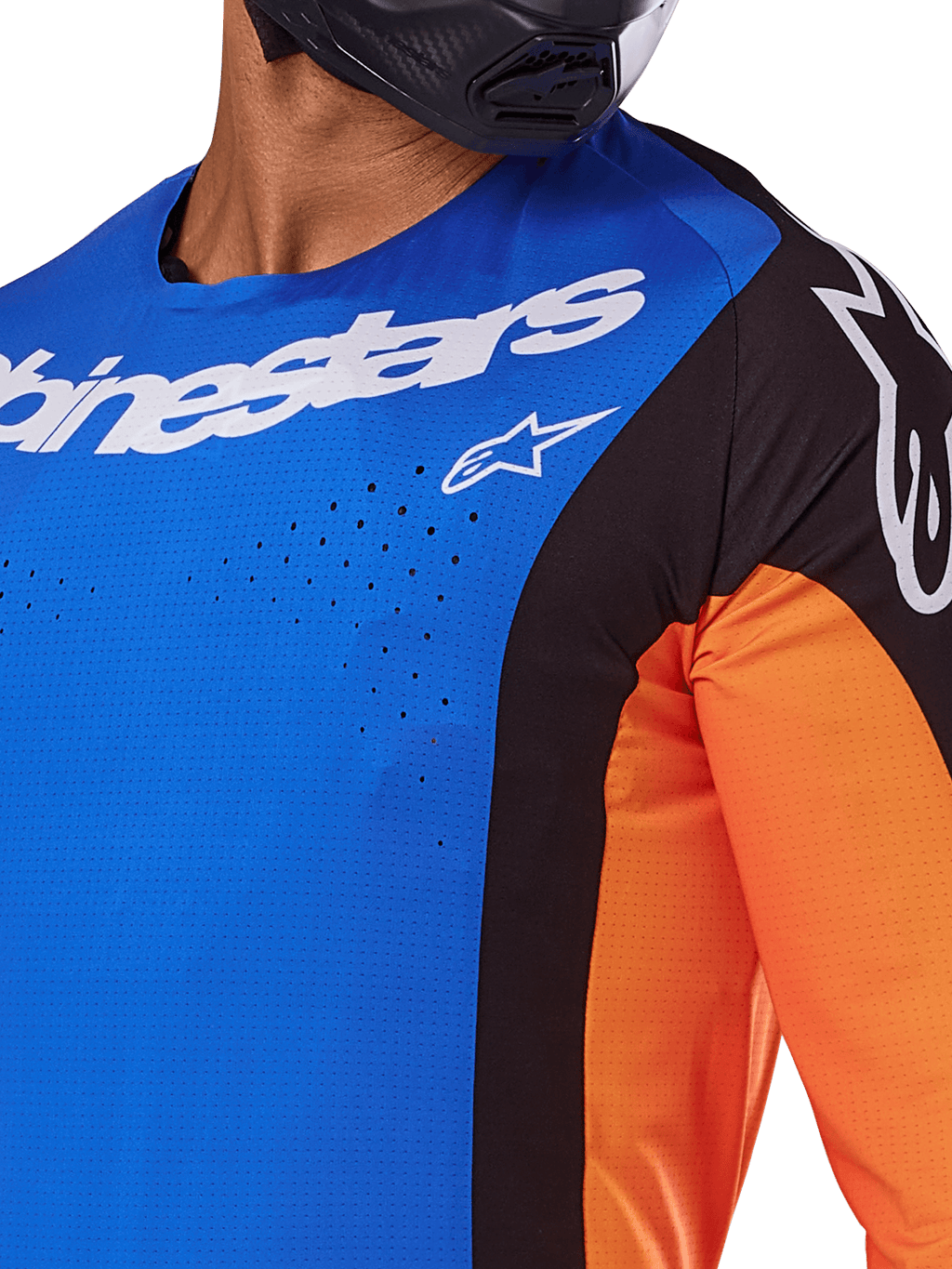 Alpinestars Techstar Melt Jersey 2025, maillot de motocross, bleu et orange avec empiècements noirs, logo Alpinestars blanc et perforations découpées au laser visibles sur la poitrine, porté par un pilote avec un casque noir