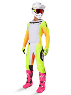 Motocross rider wearing complete racing gear featuring the Alpinestars 2025 Techstar Melt Jersey, white front with yellow side panels and orange sleeves, matching yellow and white pants, white helmet with red goggles, and vibrant pink boots, professional off-road racing kit.