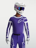Alpinestars maillot Supertech Vesta, maillot de motocross bleu foncé et blanc pour homme, maille extensible et perforations au laser, porté par un mannequin.