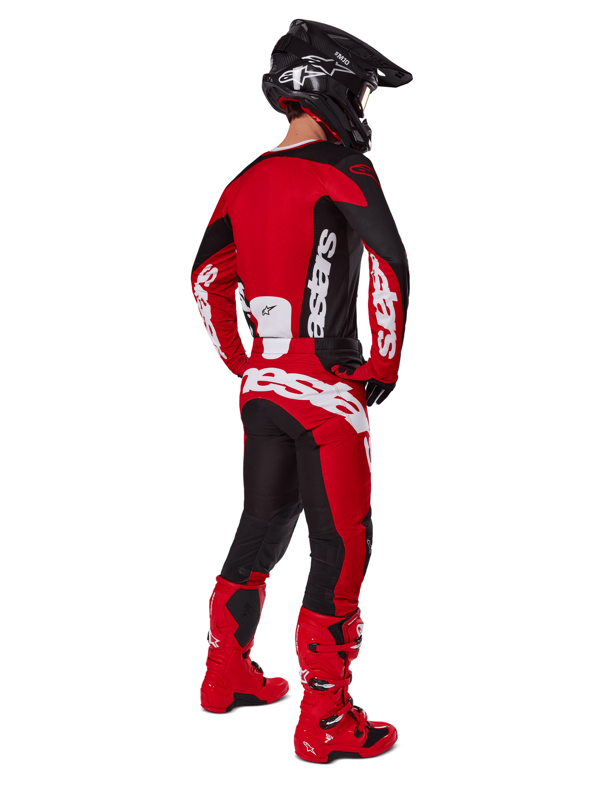 Pilote de motocross de dos portant le maillot Alpinestars Racer Veil 2025 en noir et rouge vif, assorti à un pantalon rouge et noir et des bottes de motocross rouges, avec des logos blancs imposants, idéal pour la performance tout-terrain