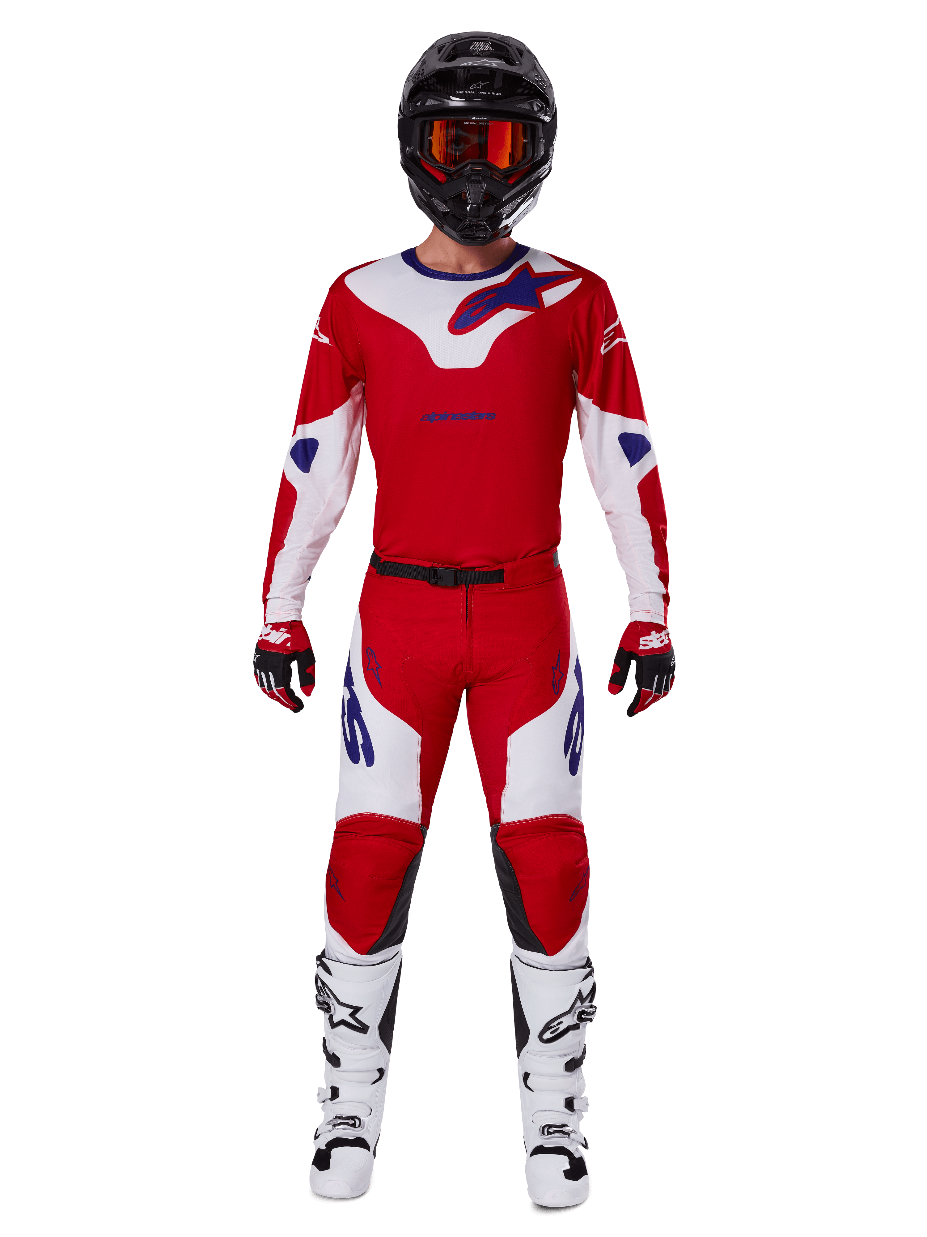 Pilote de motocross portant l'ensemble Alpinestars Racer Veil 2025, maillot et pantalon rouge vif et blanc avec accents bleus, casque noir avec lunettes rouges, bottes blanches et gants rouges et noirs, tenue coordonnée pour la course tout-terrain