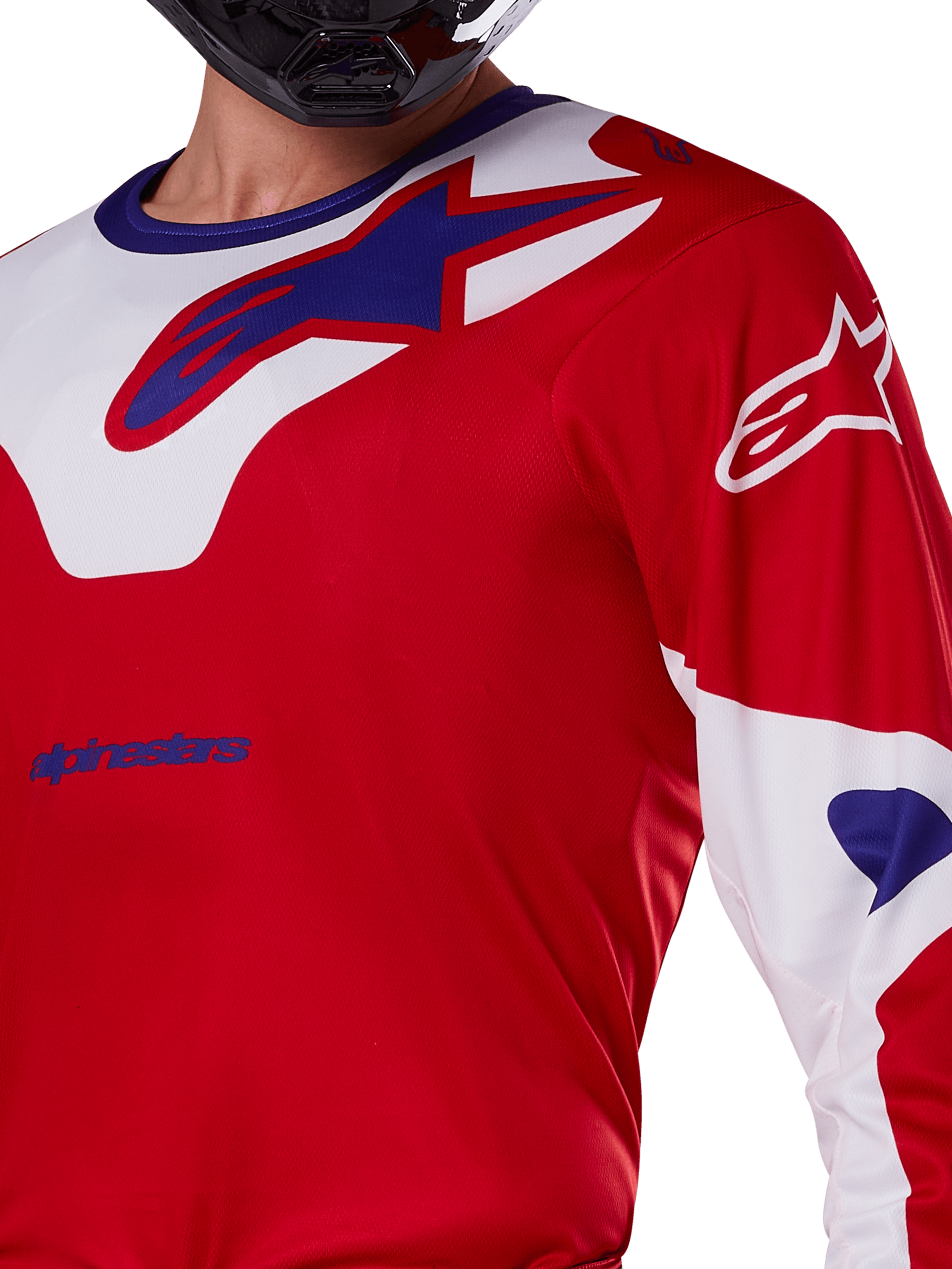 Maillot Alpinestars Racer Veil 2025, maillot de motocross, rouge vif et blanc, vue rapprochée du haut du torse et de la poitrine, logo Alpinestars bleu sur un empiècement de col blanc, manches rouges avec accents blancs, porté avec un casque noir, vêtement technique de conduite tout-terrain