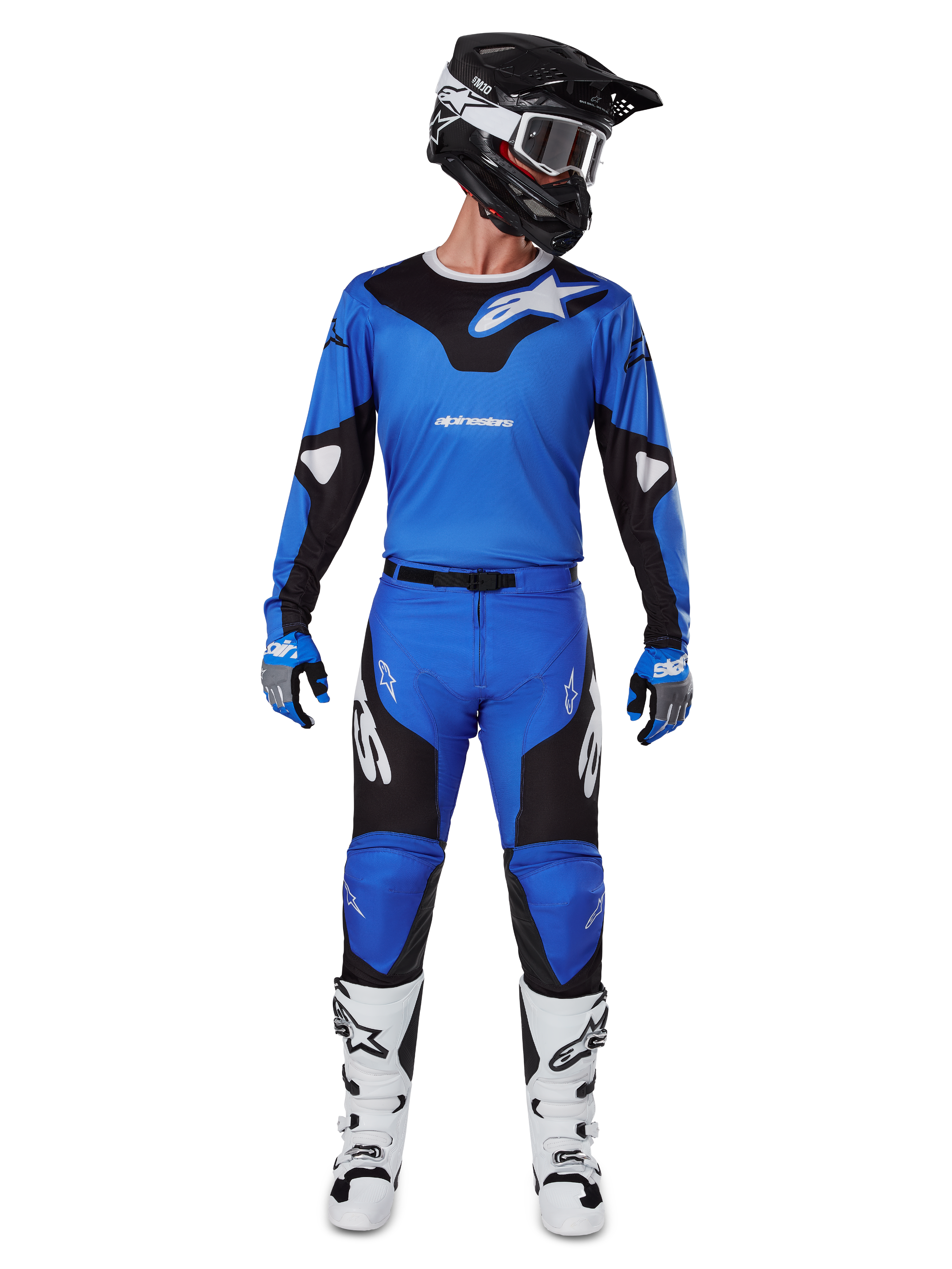 Motocross rider wearing the Alpinestars 2025 Racer Veil Gear Set, blue and black jersey with matching pants, black helmet with white goggles, white and black boots, coordinated racing outfit for off-road motocross.