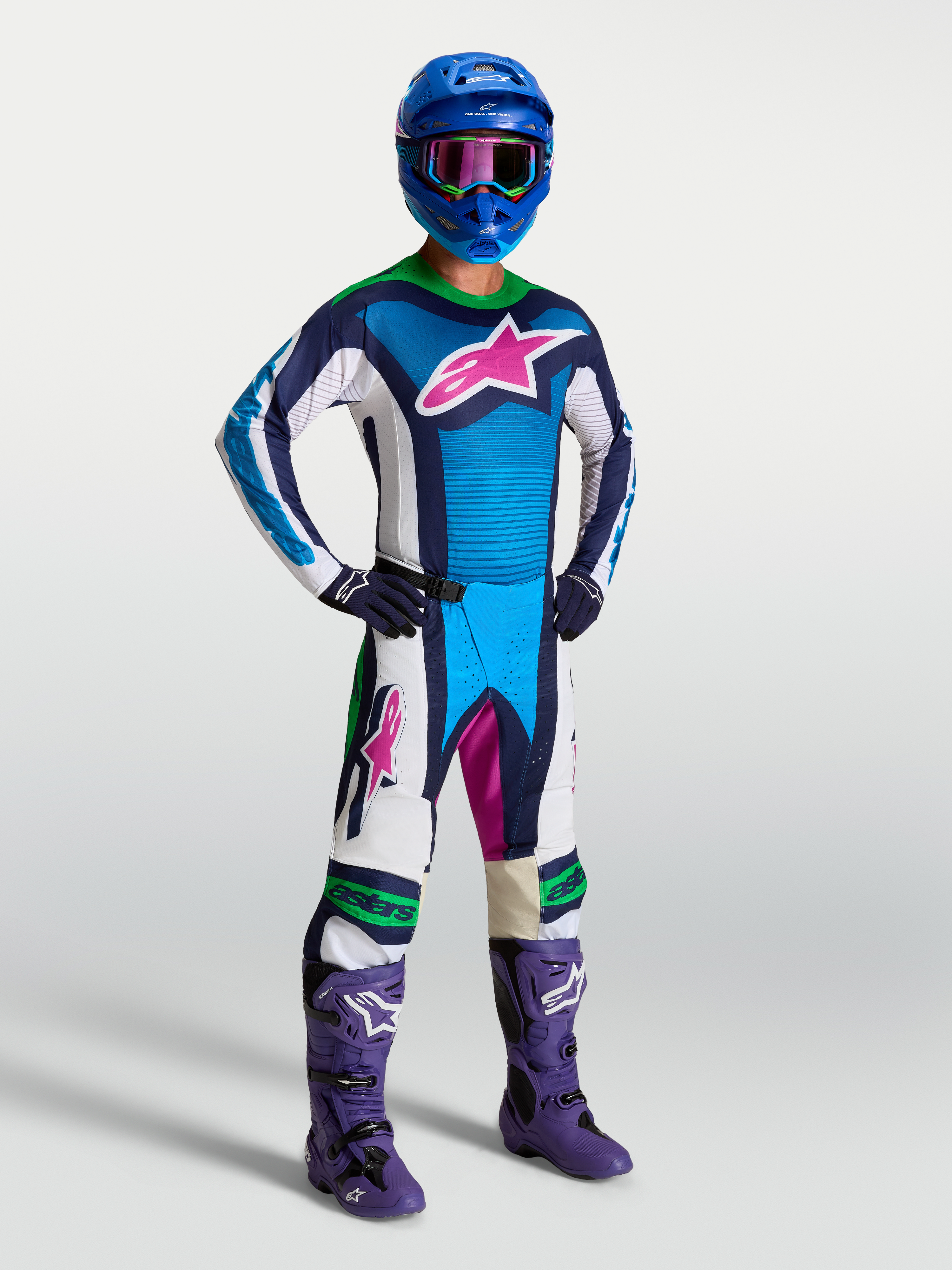 Alpinestars Maillot Techstar Maven, maillot de motocross bleu et blanc avec logo rose, pour homme, coupe athlétique et tissu respirant, porté par un pilote avec équipement tout-terrain.