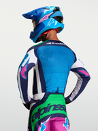 Maillot Techstar Maven Alpinestars, maillot de motocross pour homme, bleu et vert avec accents roses, vue de dos sur mannequin, textile technique respirant avec perforations laser pour une performance off-road optimale.