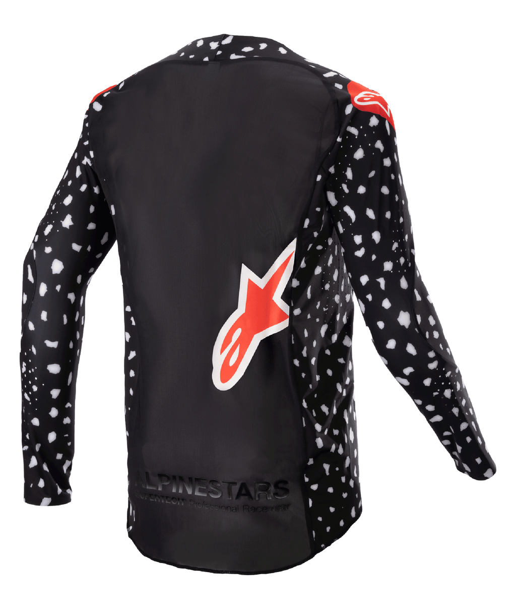 Alpinestars Maillot Supertech North 2023, maillot de motocross, noir avec motif moucheté blanc et accents rouge néon, vue de dos avec grand logo Alpinestars rouge et marquage au bas, équipement de course tout-terrain professionnel