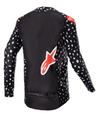 Alpinestars Maillot Supertech North 2023, maillot de motocross, noir avec motif moucheté blanc et accents rouge néon, vue de dos avec grand logo Alpinestars rouge et marquage au bas, équipement de course tout-terrain professionnel