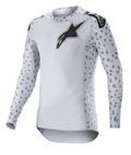Alpinestars Supertech North Jersey 2023, maillot de motocross, gris brume et noir, maillot à manches longues blanc avec motifs tachetés gris sur les manches et les côtés, logo étoile noir sur la poitrine et les épaules, maille extensible haute performance avec ourlet courbé