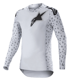 Alpinestars Supertech North Jersey 2023, maillot de motocross, gris brume et noir, maillot à manches longues blanc avec motifs tachetés gris sur les manches et les côtés, logo étoile noir sur la poitrine et les épaules, maille extensible haute performance avec ourlet courbé