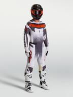 Alpinestars 2027 Techstar Swan Gear Set, professional motocross racing outfit in light lilac, dark gray, and red fluo on a model with white boots and helmet.