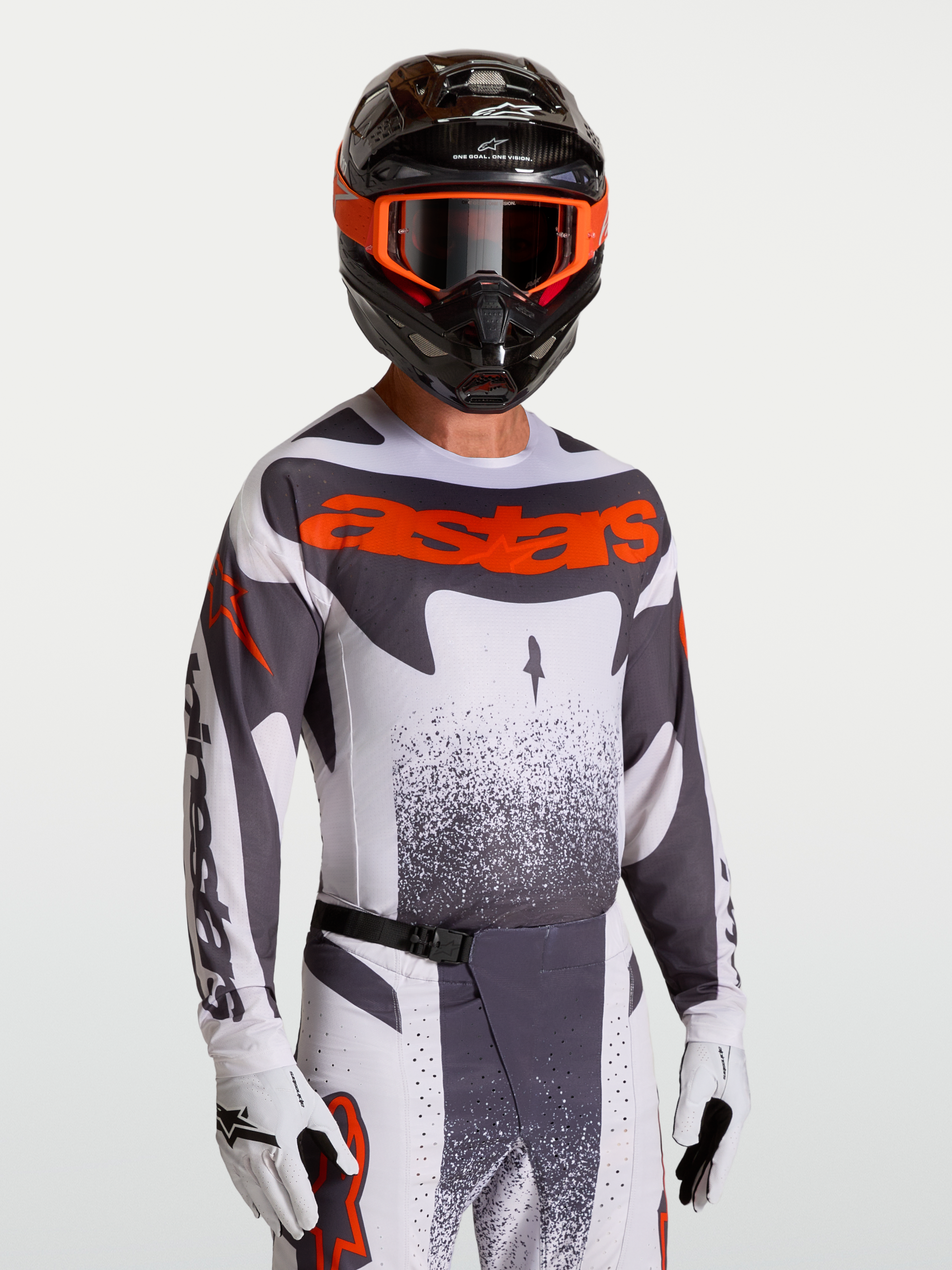 Maillot Alpinestars Techstar Swan, maillot de motocross pour homme, gris et rouge fluo, coupe athlétique extensible avec perforations laser pour la ventilation, porté par un pilote