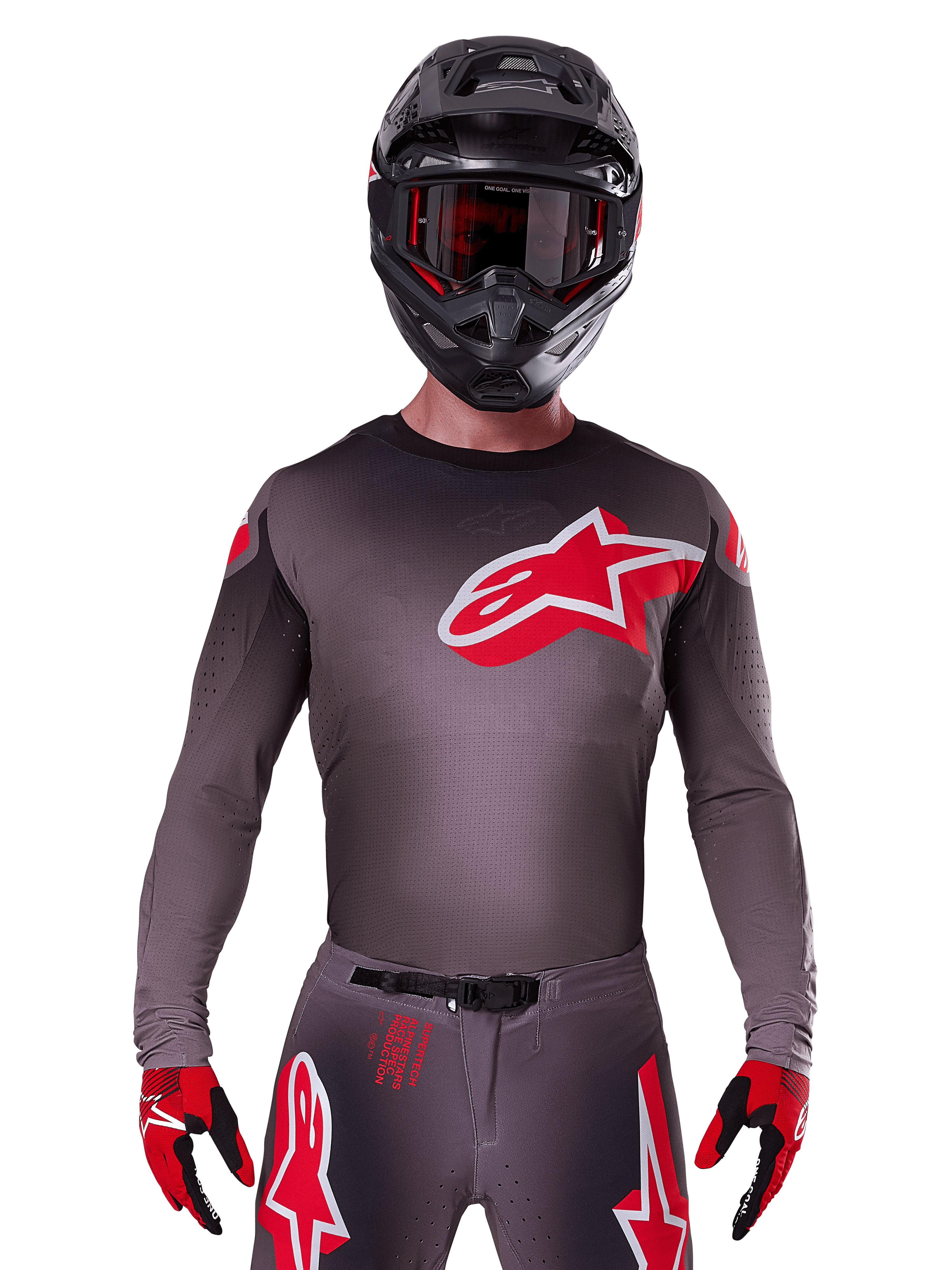 Maillot Alpinestars Supertech Lipan 2025, maillot de motocross, gris fumé et rouge, avec grand logo rouge et blanc sur la poitrine, porté avec casque noir et gants rouges et noirs, coupe athlétique avec perforations découpées au laser