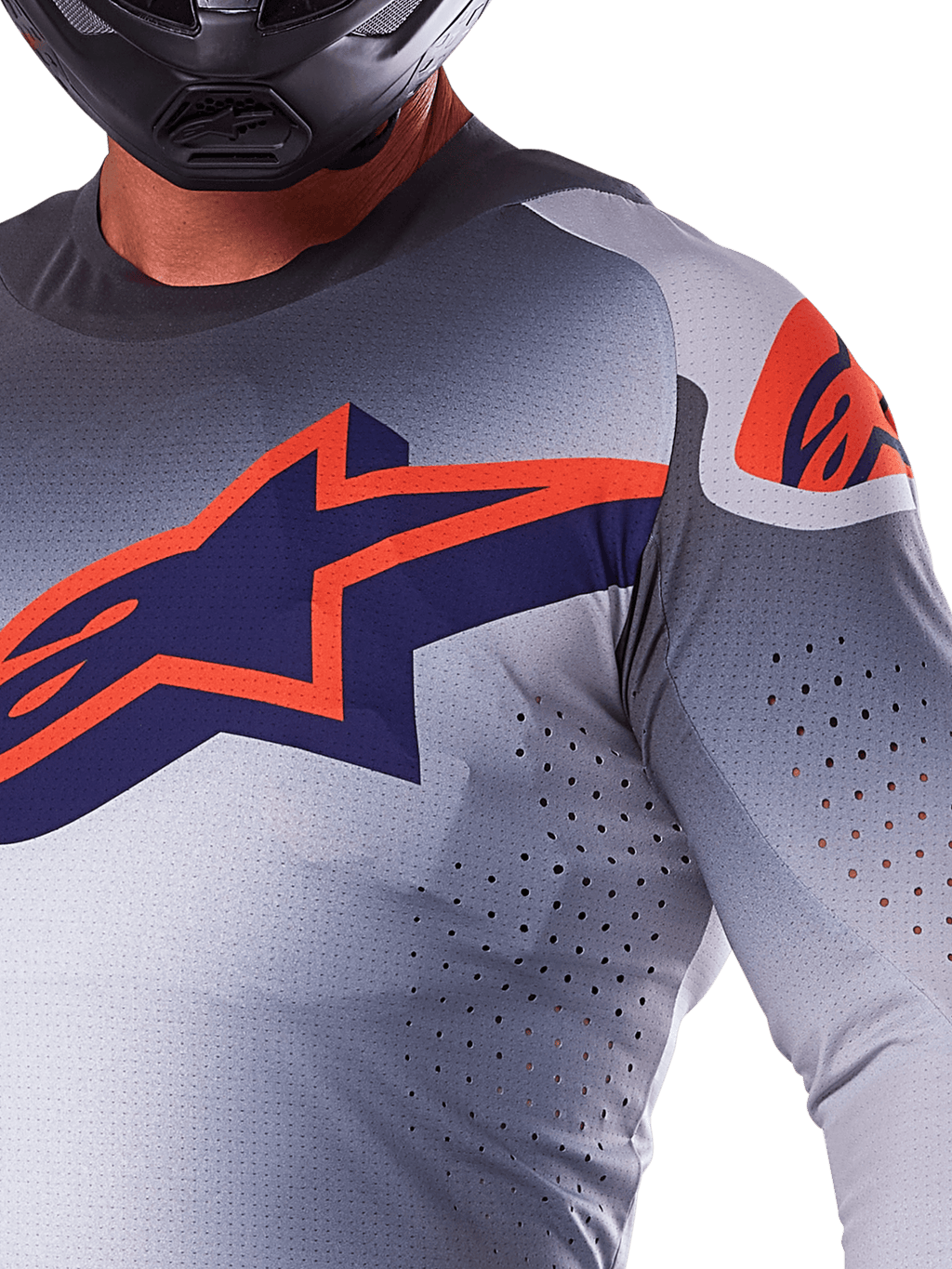 Maillot Alpinestars Supertech Lipan 2025, maillot de motocross gris et orange fluo, arborant un grand logo étoilé bleu marine et orange sur la poitrine, perforations découpées au laser pour la ventilation, construction en maille légère, porté avec un casque noir