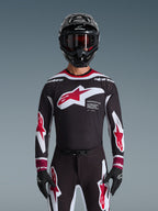 Ensemble d'équipement Alpinestars Supertech AFD Vista 2026, tenue de motocross, maillot noir avec logos rouges et blancs et marquage 'Supertech AFD', pantalon noir assorti avec accents rouges, casque noir avec lunettes rouges, tenue de course professionnelle coordonnée