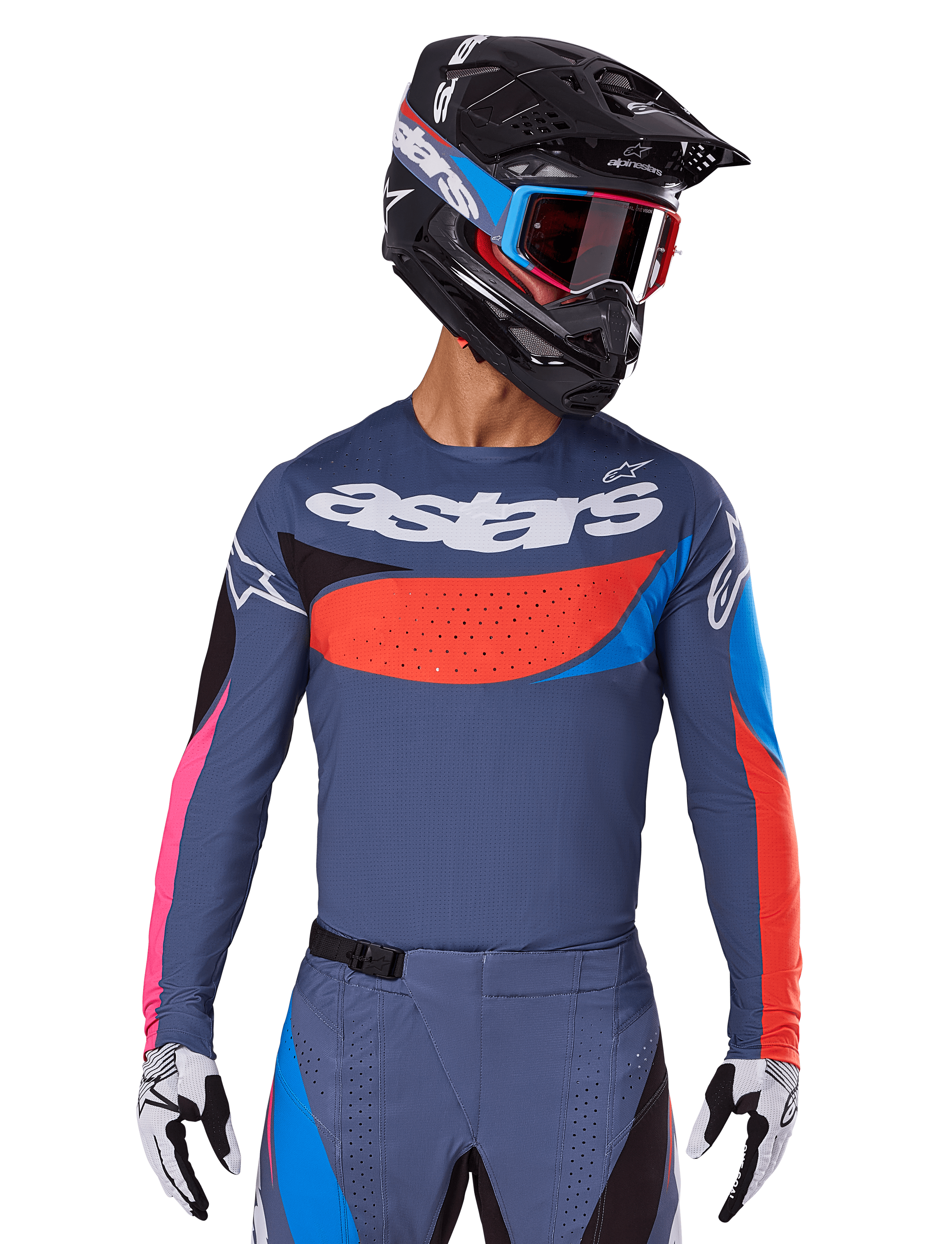 Maillot Alpinestars Techstar Dreem 2025, maillot de motocross, gris avec accents bleus, rouges et roses, doté de perforations découpées au laser et d'un logo imposant sur la poitrine, porté avec un pantalon assorti et un casque de course noir