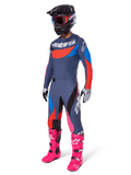 Alpinestars 2025 Techstar Dreem Motocross Gear Set, complete off-road racing outfit featuring a gray and blue jersey with red accents, matching pants with pink highlights, black helmet, bright pink boots, and white and black gloves