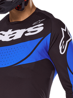 Maillot Alpinestars Techstar Dreem 2025, haut de motocross noir et bleu pour homme, ventilé avec perforations laser.