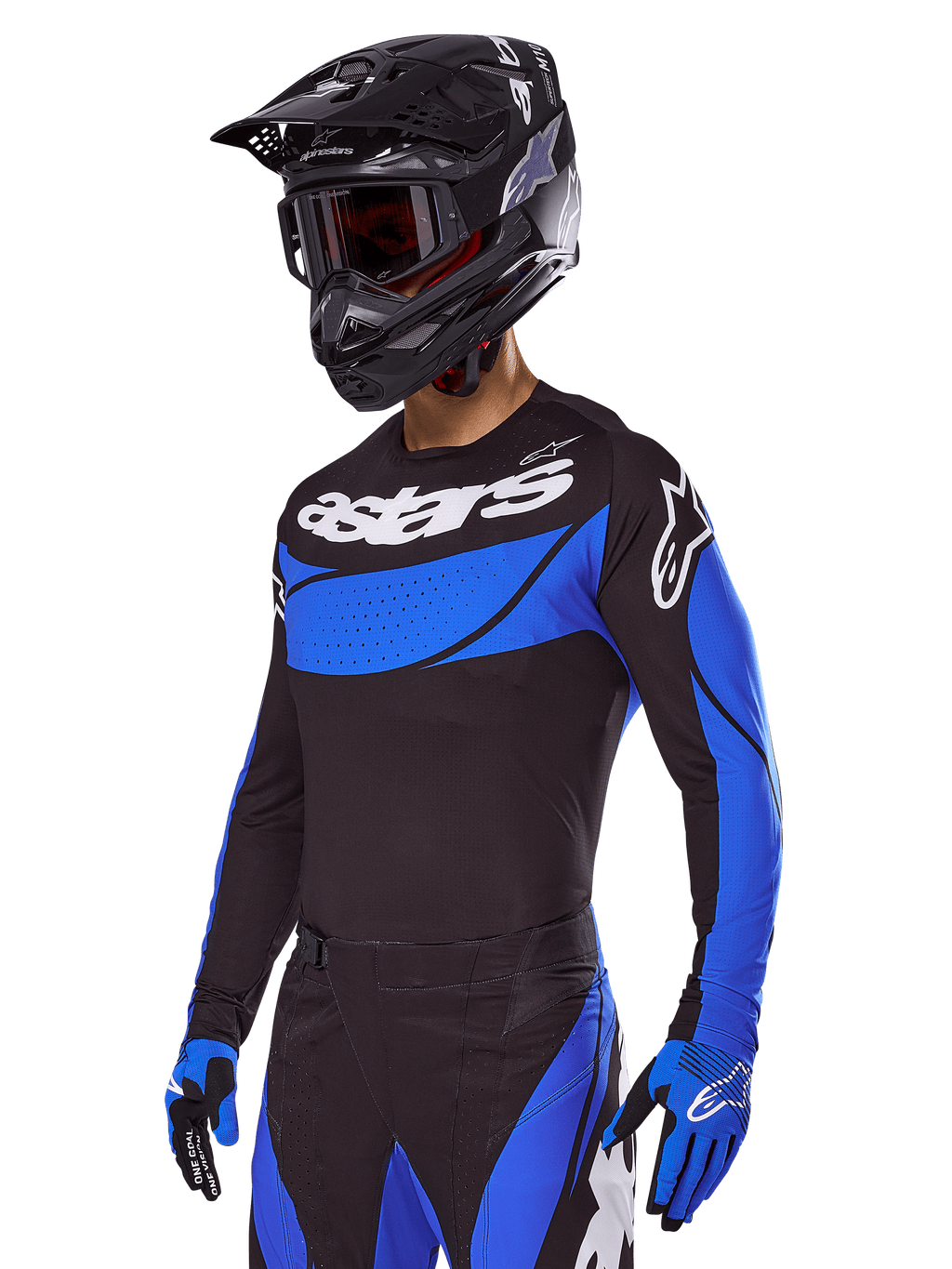 Pilote de motocross portant la tenue Alpinestars Techstar Dreem 2025, maillot noir avec empiècements bleus au style perforé et logos blancs, pantalon noir et bleu assorti, casque de course noir et gants bleus, tenue de performance coordonnée pour le motocross tout-terrain.